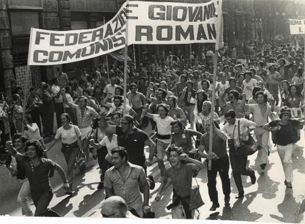 Milano - Festa nazionale de l'Unità 1973 - Manifestazione di chiusura - Spezzone di corteo con i giovani della Federazione comunista romana che corrono con il pugno chiuso alzato - Striscioni - Bandiere