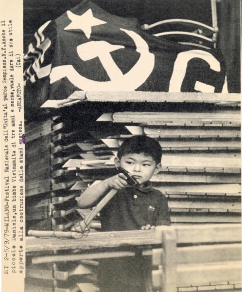 Milano - Festa nazionale de l'Unità 1979 - Parco Sempione - Un bimbo vietnamita aiuta nella costruzione degli stand - Bandiera - Attrezzi - Ritratto infantile