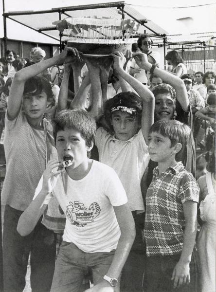 Genova - Festa provinciale de l'Unità 1980 - Bambini trasportano una torta recante un cartello "Vogliamo il tempo pieno"