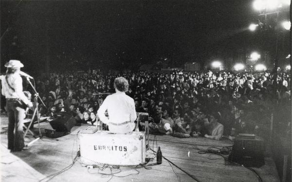 Correggio - Festa provinciale de l'Unità 1980 - Manifestazione musicale all'aperto - Cantante al microfono - Tastierista di spalle - Folla - Veduta notturna