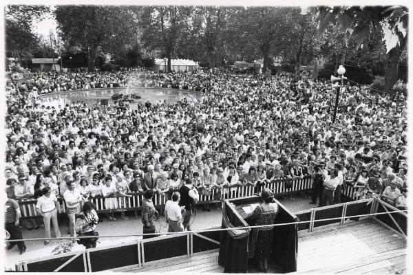 Bologna - Festa nazionale de l’Unità delle donne 1982 - La presidente della Camera Nilde Jotti parla dal palco - Cineoperatori e tecnici riprendono l'ospite e la folla