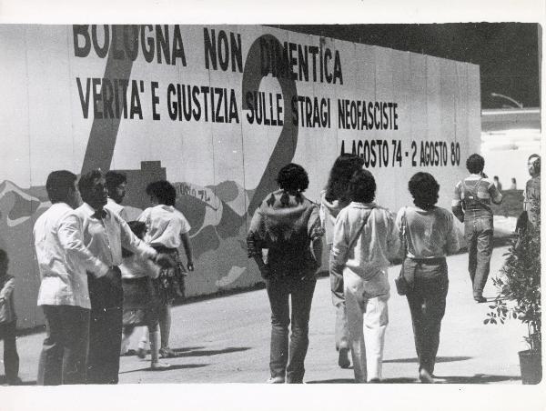 Bologna - Festa provinciale de l'Unità 1982 - Grande pannello con disegni e scritte antifasciste  - Persone a passeggio