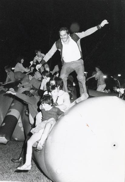 Modena - Festa provinciale de l'Unità 1981 - Bambini e ragazzi giocano su strutture gonfiabili - Un uomo cerca di mantenersi in piedi - Veduta notturna - Ritratto di gruppo