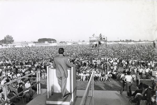 Reggio nell'Emilia - Festa nazionale de l'Unità 1983 - Campovolo - Manifestazione di chiusura - Enrico Berlinguer (di schiena) al microfono - Cineoperatori e fotografi riprendono l'ospite e la folla - Strutture