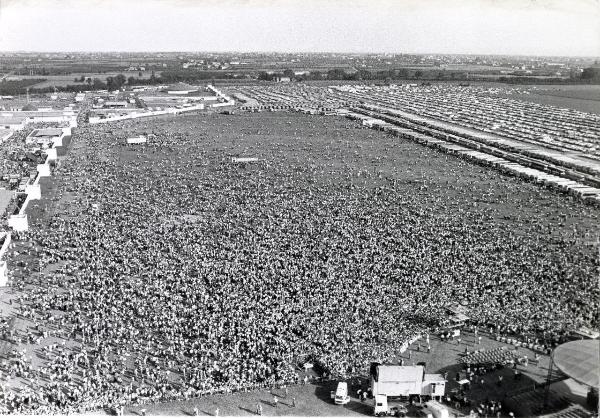 Reggio nell'Emilia - Festa nazionale de l'Unità 1983 - Manifestazione di chiusura - Veduta aerea del campovolo con la folla e le strutture adiacenti - Palco degli oratori - Strutture per le riprese - Trasporti