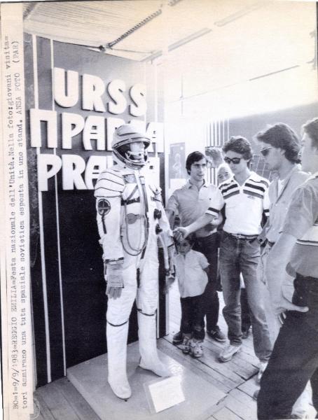 Reggio nell'Emilia - Festa nazionale de l'Unità 1983 - Stand dell'Unione Sovietica - Un gruppo di giovani osserva una tuta spaziale - Cartello - Ritratto di gruppo