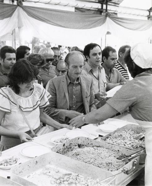 Milano - Festa provinciale de l'Unità 1983 - Ristorante con banco di distribuzione - Alcune persone attendono di essere servite - Cuoca di spalle - Ritratto di gruppo