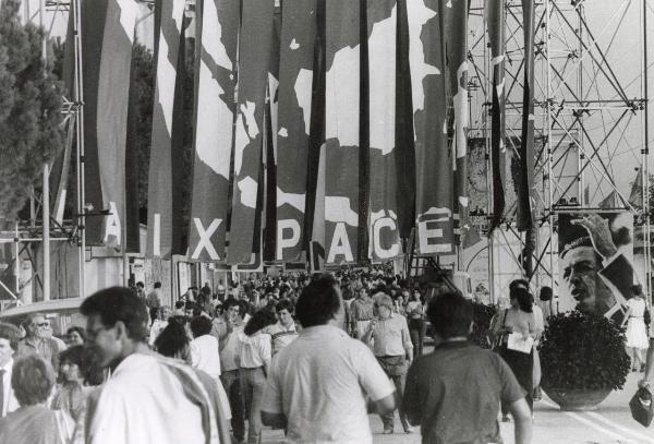 Roma - Festa nazionale de l'Unità 1984 - Folla a passeggio tra i viali dell'EUR dedicati alla festa - Bandiere per la pace -  Strutture metalliche - Grande manifesto con il ritratto di Enrico Berlinguer