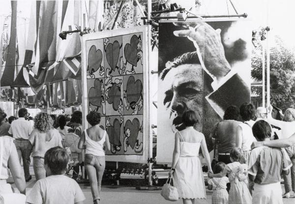 Roma - Festa nazionale de l'Unità 1984 - Folla a passeggio tra i viali dell'EUR dedicati alla festa - Strutture metalliche con pannelli decorati - Grande manifesto con il ritratto di Enrico Berlinguer