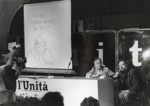 Roma - Festa nazionale de l'Unità 1984 - EUR - Incontro con Sergio Staino - Ritratto - Disegno con fumetto sopra il tavolo - Cineoperatore e microfonista - Cartello