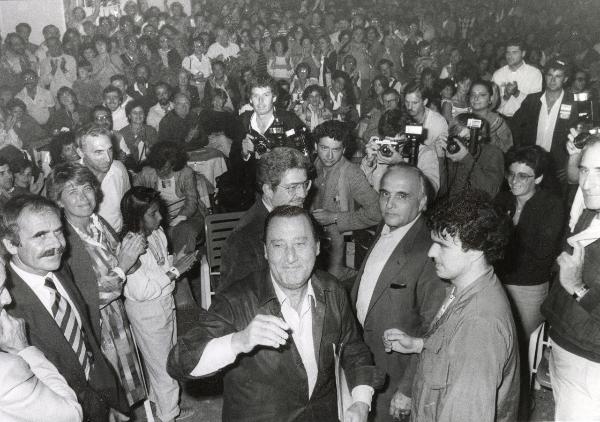 Roma - Festa nazionale de l'Unità 1984 - EUR - Tendone "Effetto comico" - Alberto Sordi (al centro) in mezzo alla folla - Alle sue spalle il regista Ettore Scola - Ritratto di gruppo - Fotografi - Pubblico che applaude