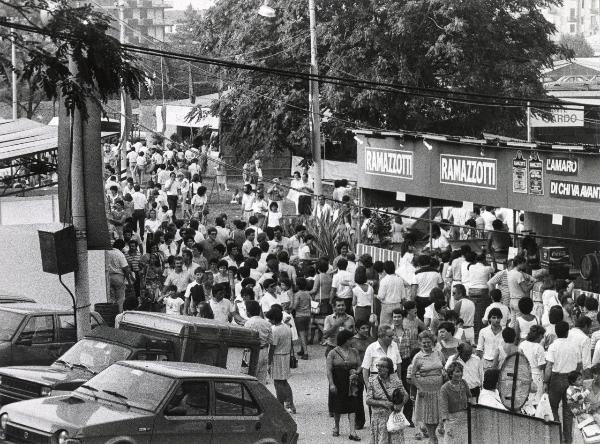 Milano - Festa provinciale de l'Unità 1984 - Monte Stella - Folla a passeggio tra gli stand - Bandiere - Automobili - Cartelli