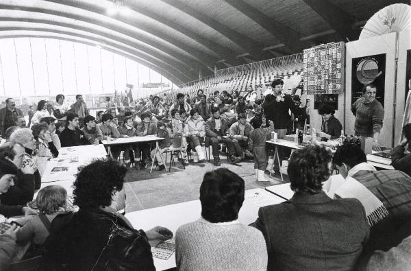 Bormio - VII Festa nazionale de l'Unità sulla neve 1985 - Palazzo dello Sport - La tombola - Numerosi giocatori seduti ai tavoli attendono l'estrazione dei numeri