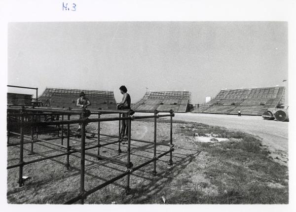 Ferrara - Festa nazionale de l'Unità 1985 - Aeroporto militare - Costruzione dell'Arena - Operai al lavoro su una struttura metallica - Mezzi da lavoro