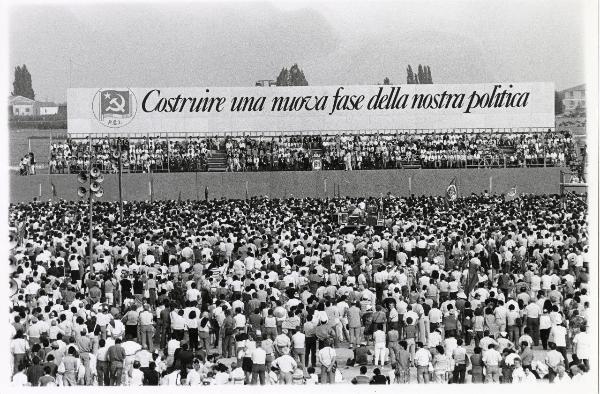 Ferrara - Festa nazionale de l'Unità 1985 - Aeroporto militare - Arena - Manifestazione di chiusura - Vista frontale del palco degli oratori - Grande cartellone con scritta - Bandiere e simboli con falce e martello - Folla