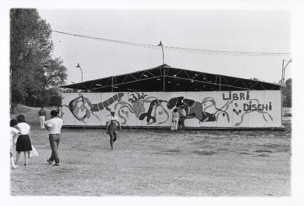 Milano - Festa provinciale de l'Unità 1985 - Monte Stella - Libreria - Murale dipinto su un lato esterno - Strutture metalliche - Scritte - Visitatori a passeggio