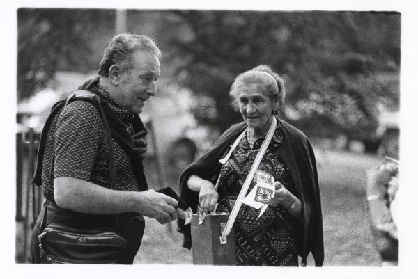 Milano - Festa provinciale de l'Unità 1985 - Monte Stella - Anziana "coccardista" vende gli adesivi a un uomo - Ritratto  di gruppo