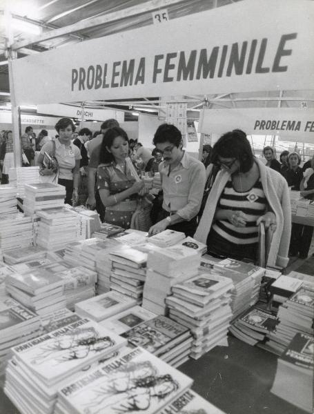 Bologna - Festa provinciale de l'Unità 1976 - Libreria - La parte  dedicata al problema femminile - In primo piano "Partigiane della libertà" - Visitatori osservano i volumi esposti - Striscioni - Scritte