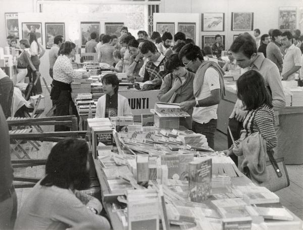 Torino - Festa provinciale de l'Unità 1976 - Libreria - Visitatori sfogliano dei volumi - Addetti alle vendite - Pannelli espositivi con manifesti