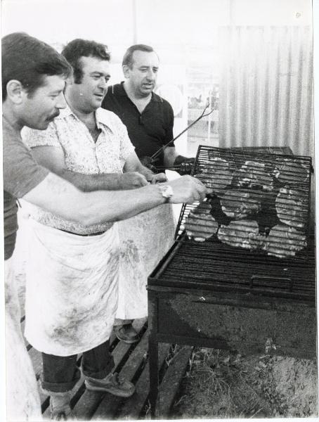 Bologna - Festa provinciale de l'Unità 1977 - Quartiere Santa Viola - Tre uomini addetti alla griglia all'aperto - Ritratto di gruppo