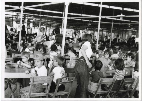 Ravenna - Festa provinciale de l'Unità 1975 - Spazio mensa - La distribuzione della merenda - Animatrici servono i bambini seduti ai tavoli - Ritratto di gruppo infantile