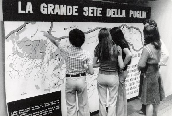 Bari - Festa nazionale d'apertura de l'Unità 1974 - Un gruppo di bambini osserva un cartellone dedicato alla scarsità di acqua in Puglia