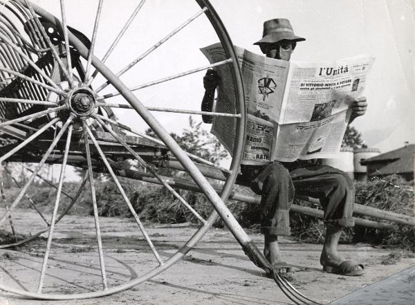 Diffusione e lettura de l'Unità - Un contadino legge una copia del giornale seduto su un erpice