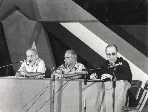 Milano - Festa nazionale de l'Unità 1973 - Parco Sempione - Dibattito sulla situazione internazionale - Palco - Un oratore al microfono - A destra padre David Maria Turoldo - Ritratto di gruppo