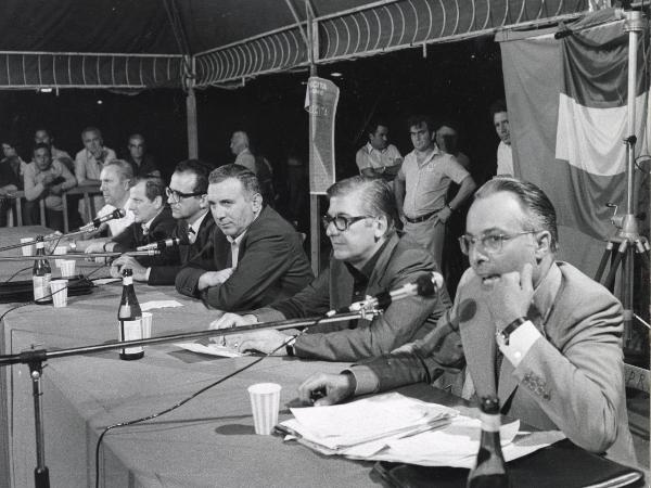 Milano - Festa nazionale de l'Unità 1973 - Parco Sempione - Dibattito "Salute della Regione" - Palco - Un oratore al microfono - Ritratto di gruppo - Bandiera - Cartello