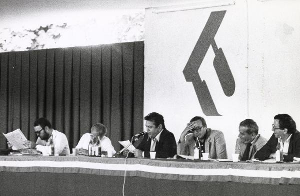 Milano - Festa nazionale de l'Unità 1979 - Parco Sempione - Dibattito - Palco degli oratori - Da sinistra: Claudio Petruccioli, Alessandro Natta, Achille Occhetto (al microfono), Adalberto Minucci, Elio Quercioli - Ritratto di gruppo - Simboli