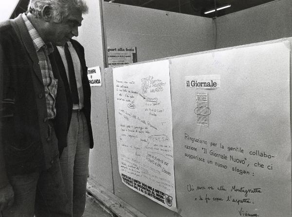 Milano - Festa provinciale de l'Unità 1981 - Monte Stella - Un uomo osserva un cartellone con scritte e ritagli di giornale - Ritratto maschile - Stand