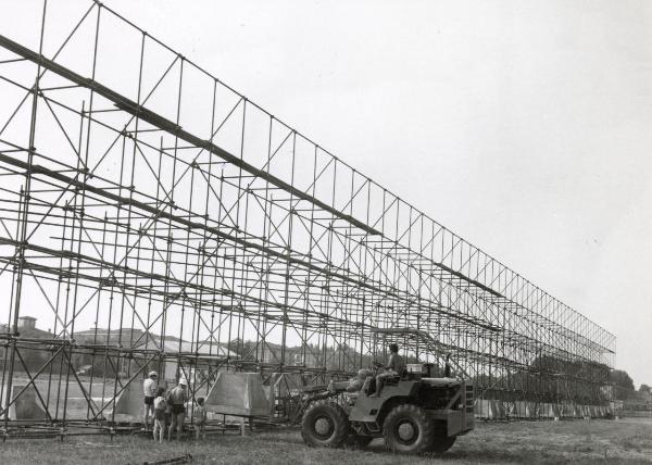 Modena - Festa provinciale de l'Unità 1982 - Costruzione dell'ingresso principale - Operai al lavoro su una grande struttura metallica - Mezzo meccanico