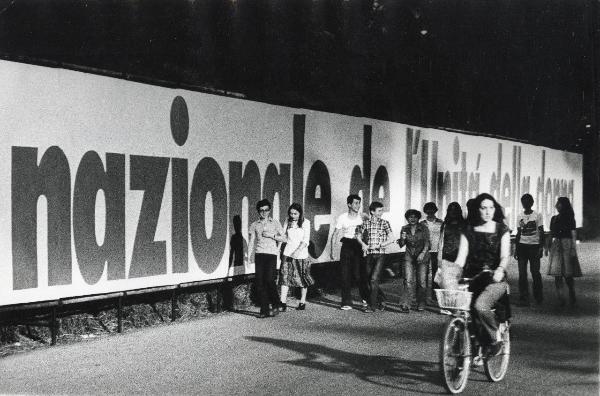 Ferrara - Festa nazionale de l'Unità delle donne 1977 - Veduta notturna - Striscione - Giovani a passeggio