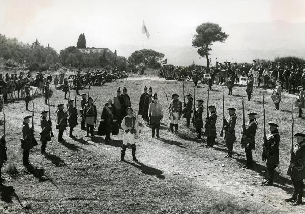 Scena del film "Fanfan la tulipe" - Regia Jacques, Christian, 1952 - Philipe Géerard, al centro, è in piedi a gambe larghe. Tutt'intorno a lui numerosi attori non identificati, in vesti militari, rivolgono lo sguardo dritto davanti a sé.
