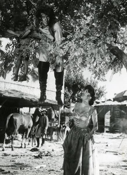 Scena del film "Fanfan la tulipe" - Regia Jacques, Christian, 1952 - Gina Lollobrigida, in piedi a destra, rivolge lo sguardo verso Philipe Gérard appeso a un albero, affiancato da un giovane attore non identificato.
