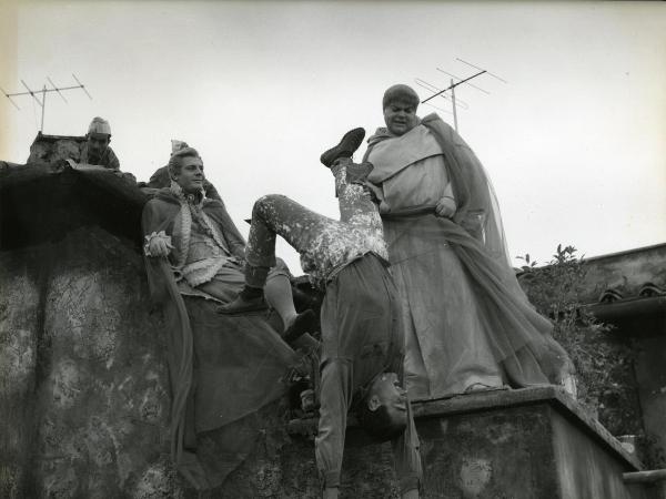 Scena del film "Fantasmi a Roma" - Regia Pietrangeli, Antonio, 1961 - Mastroianni, a sinistra, osserva divertito Buazzelli che tiene appeso a testa in giù un attore non identificato spaventato. Dietro, due attori non identificati, osservano la scena.