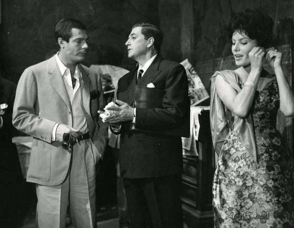 Scena del film "Fantasmi a Roma" - Regia Pietrangeli, Antonio, 1961 - Claudio Gora, al centro, parla con Marcello Mastroianni, a sinistra. A destra, un'attrice non identificata si sistema un orecchino.