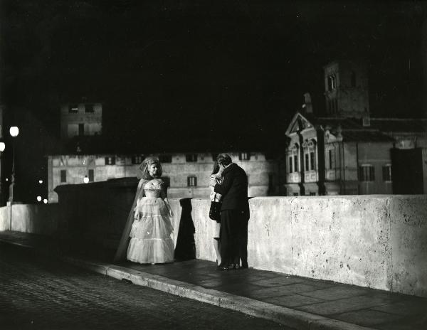 Scena del film "Fantasmi a Roma" - Regia Pietrangeli, Antonio, 1961 - Due attori non identificati si baciano mentre Sandra Mila li osserva.