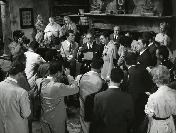 Scena del film "Fantasmi a Roma" - Regia Pietrangeli, Antonio, 1961 - Un attore non identificato, affiancato da Mastroianni, legge ad una platea di attori, fra cui si riconosce Claudio Gora. Dietro, Sandra Milo, Gassman e Buazzelli.