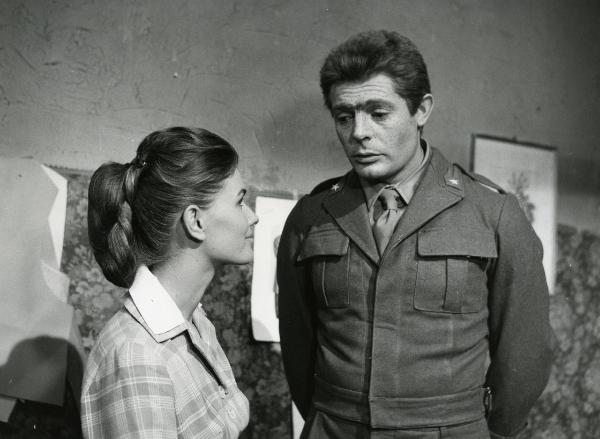 Scena del film "Fantasmi a Roma" - Regia Pietrangeli, Antonio, 1961 - Marcello Mastroianni, a destra con il viso ricoperto di macchie cutanee, conversa con un'attrice non identificata, di profilo a sinistra, che lo osserva sorridendo.
