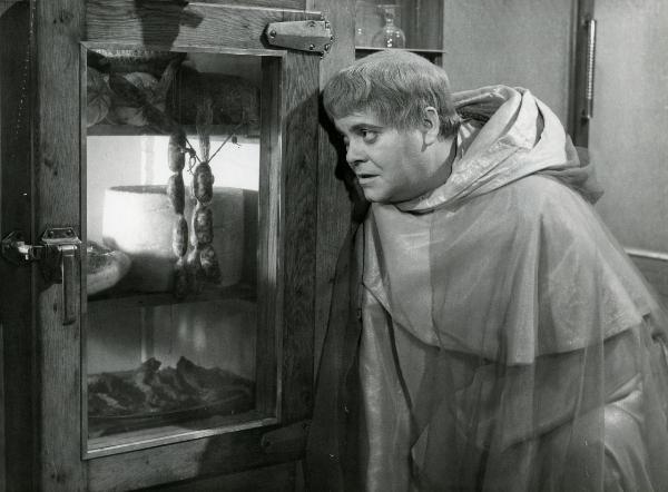 Scena del film "Fantasmi a Roma" - Regia Pietrangeli, Antonio, 1961 - Mezza figura di Tino Buazzelli che, appoggiato a una dispensa, rivolge uno sguardo affamato ai formaggi e ai salumi contenuti in essa.
