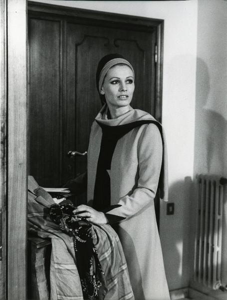 Scena del film "Una farfalla con le ali insanguinate" - Regia Tessari, Duccio, 1971 - Ida Galli, in piedi davanti a una porta, rivolge lo sguardo verso destra.
