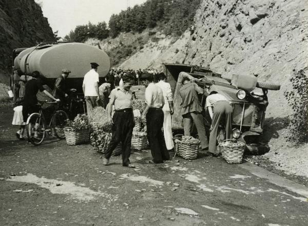 Scena del film "Fari nella nebbia" - Regia Franciolini, Gianni, 1942 - Due attori non identificati, a destra, sono intenti a controllare un'autovettura incidentata mentre, altri due attori non identificati, in centro, scherzano tra loro.