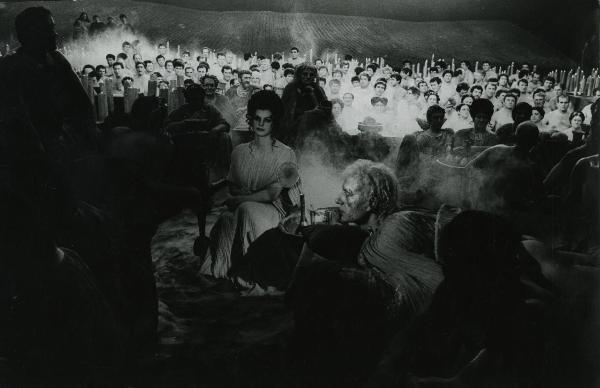 Scena del film "Fellini-Satyricon" - Fellini, Federico, 1969 - Un attore non identificato in primo piano, con il viso ricoperto di pustole, guarda a sinistra. In secondo piano, molti attori non identificati guardano verso l'obbiettivo.
