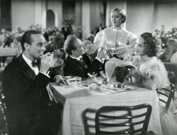 Scena del film "Il feroce Saladino" - Bonnard, Mario, 1937 - Mentre Angelo Musco, al centro, è intento a conversare con un'attrice non identificata, Alida Valli, a destra, e Lino Carenzio, a sinistra, si osservano con trasporto.
