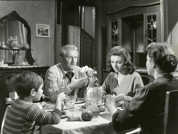 Sul set del film "Il ferroviere" - Germi, Pietro, 1956 - Pietro Germi, al centro, conversa gesticolando con Luisa Della Noce, a destra di spalle. Intanto, Sylva Koscina, al centro, rivolge lo sguardo in basso e Edoardo Nevola, a sinistra, ascolta.