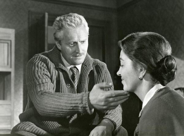 Scena del film "Il ferroviere" - Germi, Pietro, 1956 - Germi Pietro, a sinistra, avvicina dolcemente la mano sinistra al viso di Luisa Della Noce che rivolge lo sguardo verso il basso e sorride.
