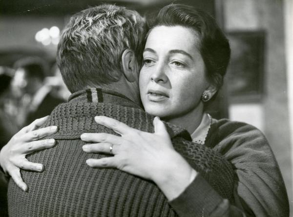 Scena del film "Il ferroviere" - Germi, Pietro, 1956 - Luisa Della Noce abbraccia un attore non identificato di spalle rivolgendo lo sguardo verso sinistra.
