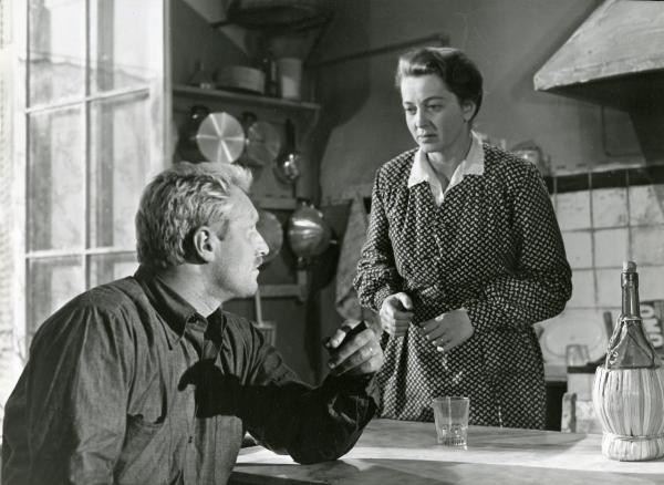 Scena del film "Il ferroviere" - Germi, Pietro, 1956 - In una cucina: Pietro Germi, in primo piano con un sigaro in mano, osserva Luisa Della Noce, in secondo piano di fronte a lui, che ricambia.
