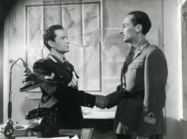 Scena del film "Fiamma che non si spegne" - Cottafavi, Vittorio, 1949 - Leonardo Cortese, a sinistra in abiti da carabiniere, sorride e stringe la mano di un attore non identificato, a destra in abiti militari.
